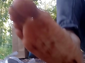 Young boy enjoys walking in the park and streets with dirty socks and shoes.