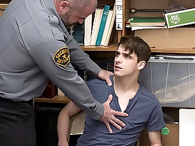 A young man is stripped by a police officer in a security room in a gay scene.