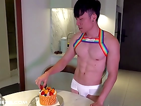 This fit Asian man with a nice six pack is enjoying a cake and teasing at the same time.