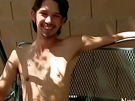 Young Asian man masturbates outdoors.