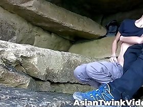 A young Asian and white gay couple having sex in a lake.